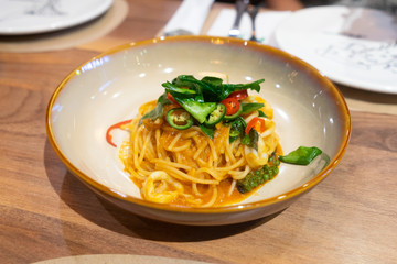 Spicy delicious pasta with wooden background