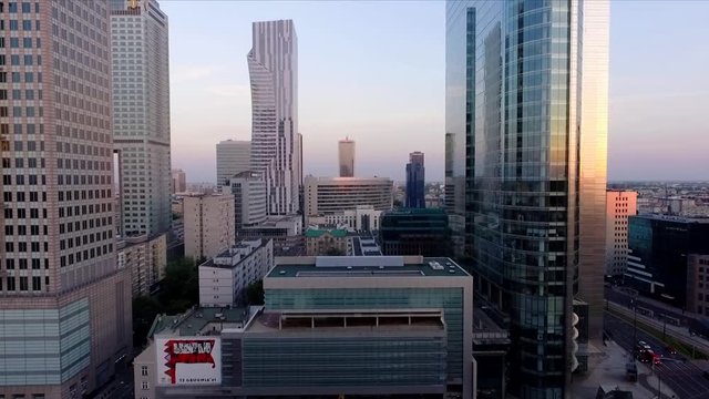 Rising aerial drone shot of skyscrapers and the city center of downtown Warsaw during sunset, Poland