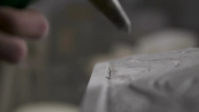 Carving a rock with a hammer