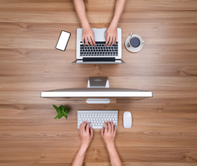 Female hands working on modern laptop. Office desktop on wooden table background