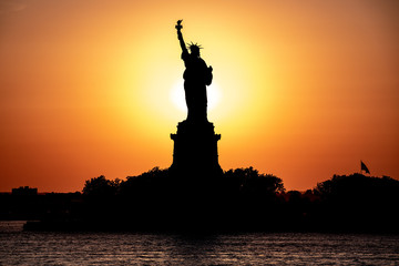 Scenic view of Statue of Liberty at a sunset. Sun behind the statue create beautiful silhouette. © Dmitry