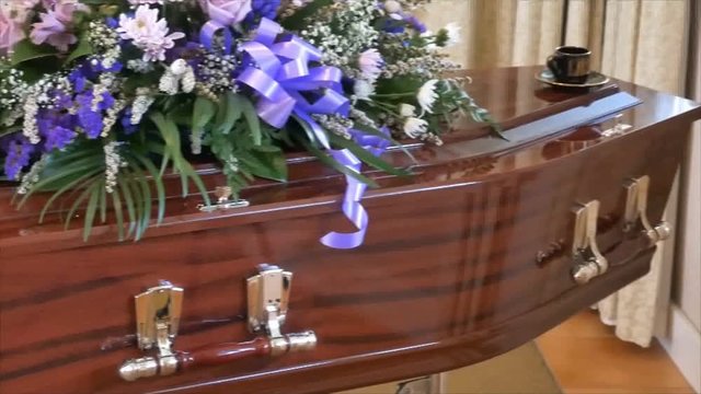 closeup shot of a funeral casket in a hearse or chapel or burial at cemetery