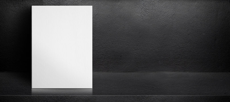 Blank white poster leaning at black interior cement room background,mock up banner template for display of design,leave side space for adding text for advertising.