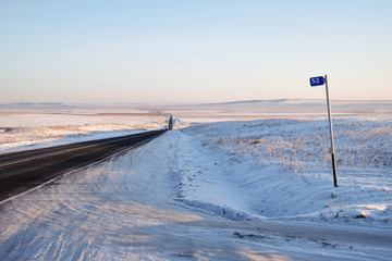 A mile marker on winter road in steppe