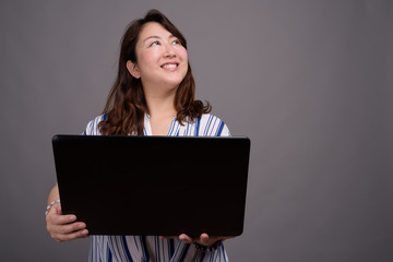 Mature beautiful Asian businesswoman using laptop computer