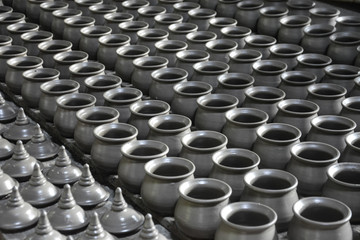 Fototapeta premium row of raw clay pot and lid on shelf in process waiting for burn in charcoal kilns