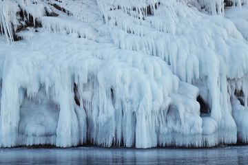 Icicles covered the rocks. Lake Baikal is a frosty winter day.