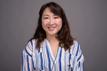 Portrait of mature Asian call center representative businesswoman