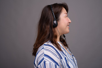 Portrait of mature Asian call center representative businesswoman