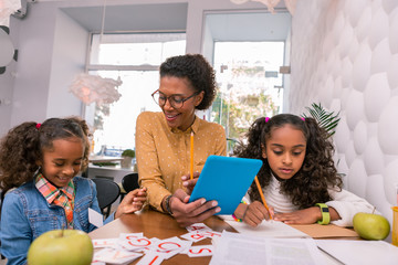 Studying in kindergarten. Two little smart diligent students feeling amazing studying in kindergarten together