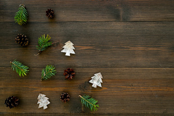 Winter ornament, New Year pattern. Pine sprigs, cones, spruce figure, fir oil on dark wooden background top view copy space