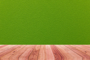 A picture of a wooden desk in front of an abstract background of green cloth.