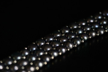 Black pearl necklace on a dark background close up