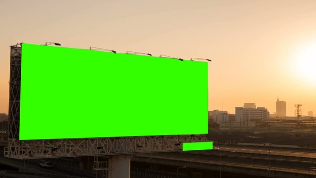 Green screen of advertising billboard on expressway during the sunset with city background in Bangkok, Thailand. Time lapse...
