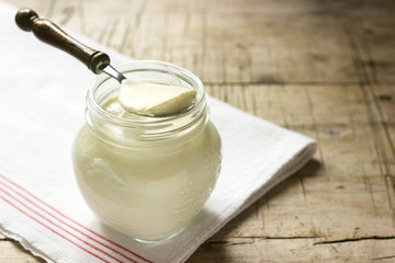 Homemade yogurt in a jar and spoon on a wooden background. Rustic style.