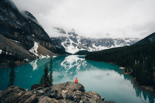 Person sitting on rock overlooking Moraine Lake, Canada