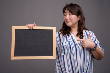 Asian businesswoman holding blackboard with copy space