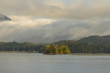 Small island and fog covering mountain range behind