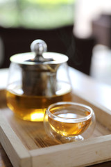 Hot teacup with teapot beverage on wooden table