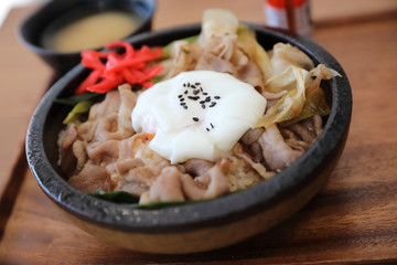 Japanese food Gyudon Japanese beef on rice bowl topped with egg on wooden table