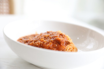 spaghetti Bolognese with minced beef and tomato sauce garnished with parmesan cheese and basil , Italian food