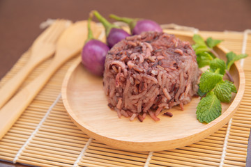 Clean food for healthy,cooked purple rice berry with peppermint leaves and purple eggplant on wooden plate