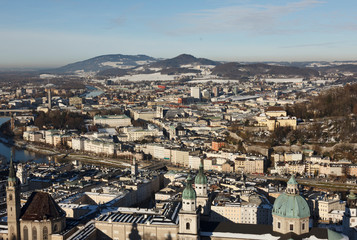 Fototapeta na wymiar panoramic winter view of the historic center of Salzburg Austria surrounded by the Alps covered with snow in a foggy haze
