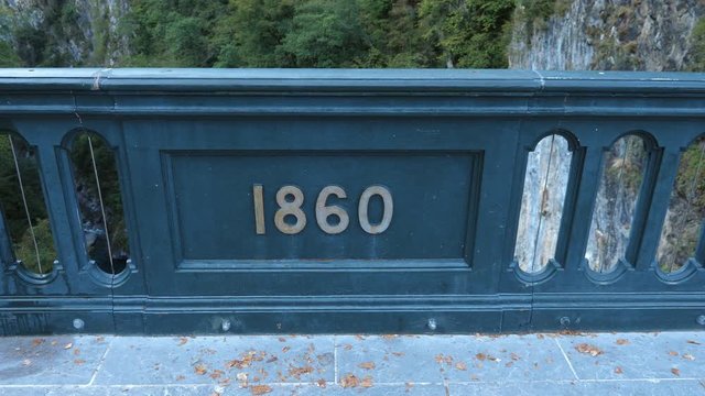 Tilt down to 1860 Plaque on the Pont Napoleon bridge near Saint-Sauveur, Pyrenees, France. Completed in 1861 for Napoleon III, the Pont Napoleon crosses the Gave de Gavarnie river. Handheld shot with 