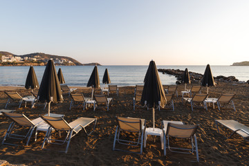 umbrellas and sunbeds on a beautiful sandy beach by the sea in the sunset and sunrise