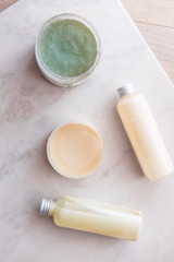 Spa cosmetics on white marble background from above. Beauty blogging concept. Copyspace