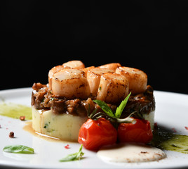 Plate with grilled scallops with butter lemon spicy sauce mashed potatoes and tomatoes