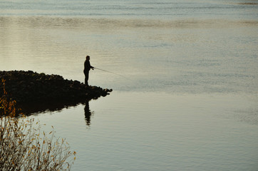 Obraz na płótnie Canvas Fisherman fishing on the river in the autumn.