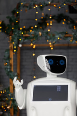 Humanoid autonomous robot on the background of Christmas decorations, Christmas tree, bokeh