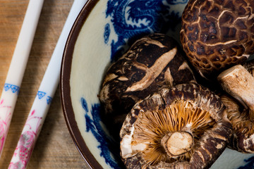 Dried shiitake mushroom in bowl with chopsticks