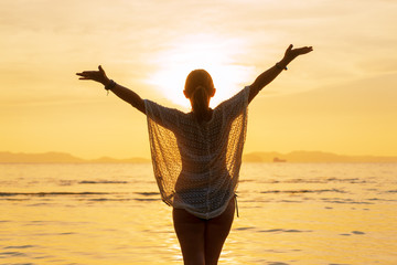 Fototapeta premium Silhouette of a Beautiful Woman at the beach in Thailand at sunset