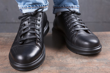 two black shoes on male legs, on a loft background, concept, front view