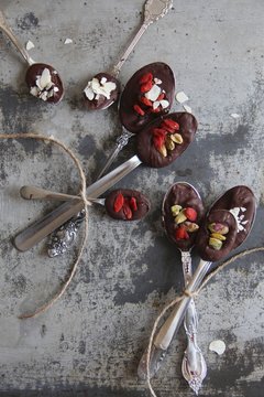 Overhead view spoons of chocolate, goaded berries and nuts