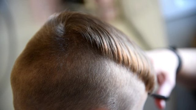 Children haircut in salon. Little boy hairdressing. Child hair styling. Hair stylist making stylish hairstyle for little boy