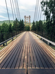 Obraz premium A large long bridge with a wooden road cover. Dark traces of use.