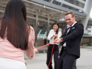 business people pull rope for fight together