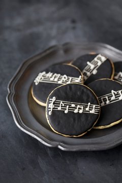 Round cookies with black icing and a stave and notes pattern