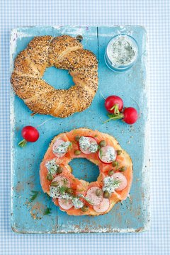 Bagel topped with smoked salmon, capers, radishes and dill sauce