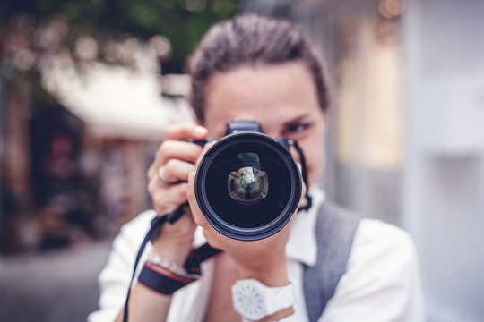 Beautiful young woman with a camera in her hands, professional at work