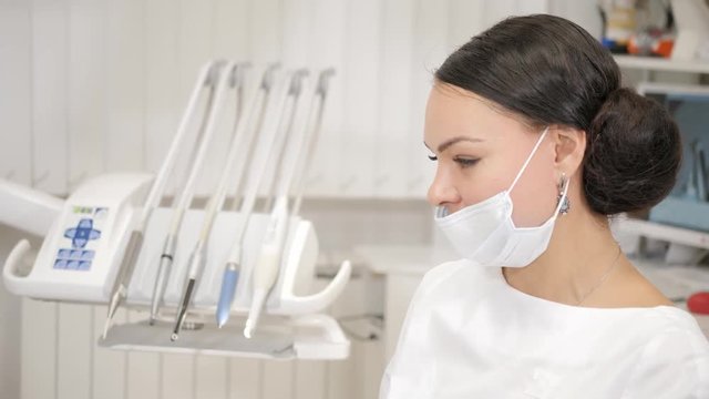 The dentist puts a shot of freezing novocaine in the jaw. Young African American male patient at chair at dental clinic. Medicine, health, stomatology concept.
