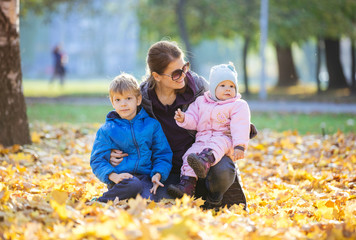 Young woman with preschool son and baby daugther enjoying beautiful day outdoors