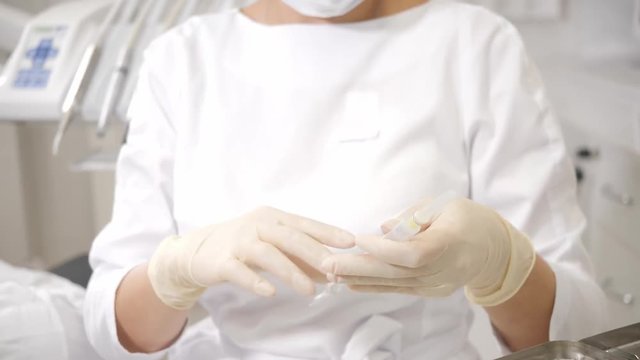 The dentist puts a shot of freezing novocaine in the jaw. Young African American male patient at chair at dental clinic. Medicine, health, stomatology concept.