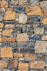 beautiful stone wall of stones of different colors close up, vertical