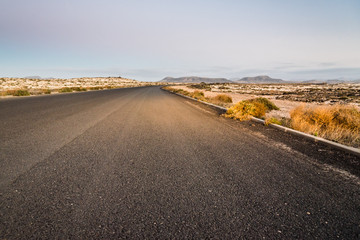 Desertic road in Fuerteventura at sunset, Spain