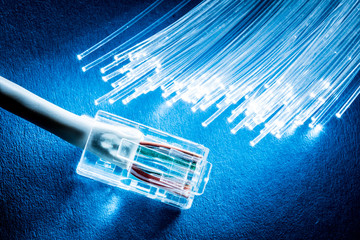 Network cable and optical fibers with lights on blue background. - obrazy, fototapety, plakaty