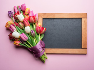 Colorful bouquet of tulips and blackboard.